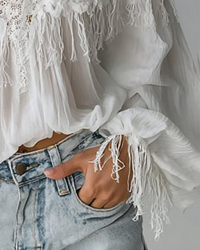 Top con spalline scoperte, pizzo e nappe